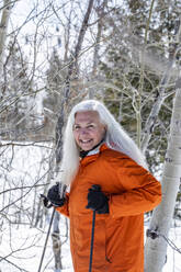 Smiling woman snowshoeing in winter - TETF02028