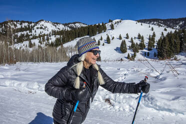 USA, Idaho, Ketchum, Senior female hiker hiking in mountains in winter - TETF02101