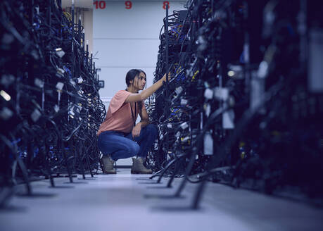 Female technician working in server room - TETF02112