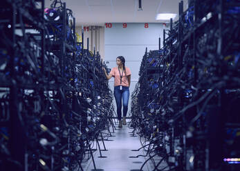 Female technician working in server room - TETF02114