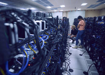 Technicians working in server room - TETF02117