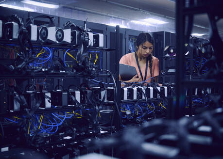 Female technician working in server room - TETF02120