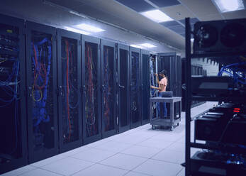 Female technician working in server room - TETF02124