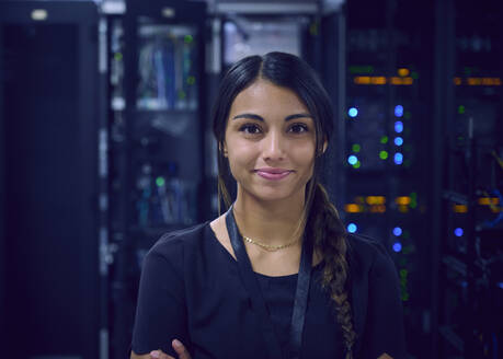 Portrait of smiling female technician in server room - TETF02132