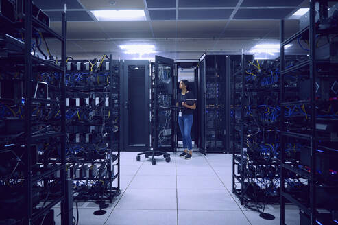 Female technician working in server room - TETF02133