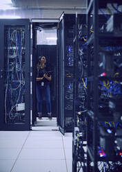 Female technician working in server room - TETF02135