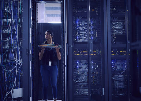 Female technician working in server room - TETF02136