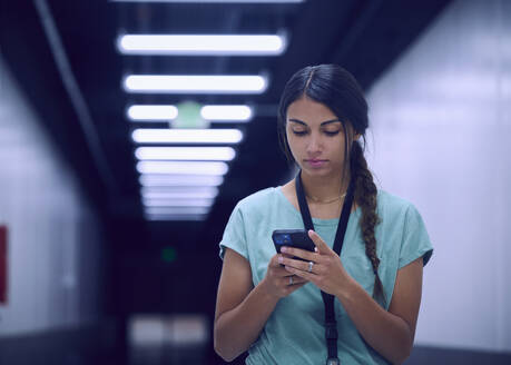 Female technician looking at smart phone - TETF02149