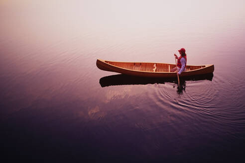 High angle view of woman paddling canoe on Lake Placid at sunrise, Adirondacks State Park - TETF02162