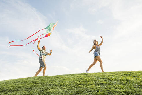 Man and woman flying kite in park - TETF02169