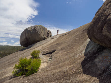 Australia, Queensland, Girraween National Park, Woman hiking on rock formation - TETF02176