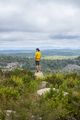 Australia, New South Wales, Bald Rock National Park, Man standing on rock and looking around - TETF02178