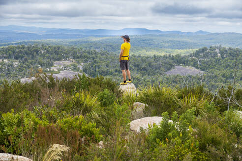 Australia, New South Wales, Bald Rock National Park, Man standing on rock and looking around - TETF02179