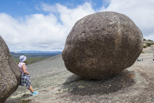 Australia, New South Wales, Bald Rock National Park, Woman standing next to large boulder - TETF02181