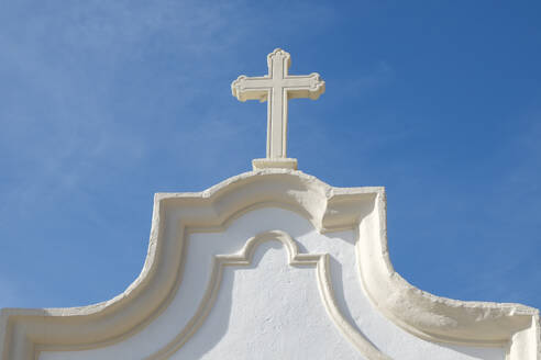 Portugal, Torres Novas, Cross on white church against blue sky - TETF02226