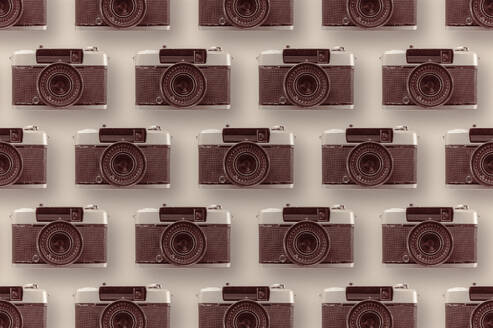 Background of assorted vintage photo cameras arranged in rows on bright surface with lens - ADSF44389