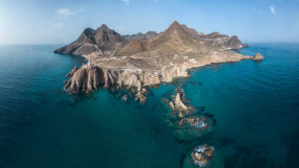 Drone view of lighthouse located on rough cliff near sea under cloudy sky in Almeria - ADSF44422