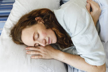 Lächelnde Frau mit geschlossenen Augen auf dem Bett schlafend - TYF00797
