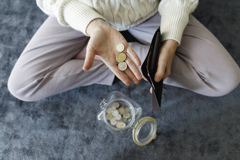 Hand einer Frau beim Zählen von Münzen zu Hause - TYF00800