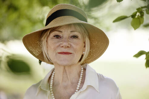 Senior woman wearing hat in park - JATF01369