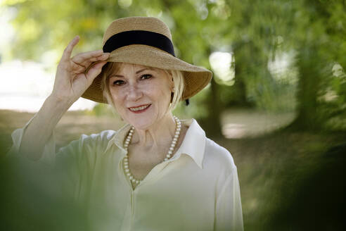 Smiling senior woman wearing hat - JATF01370