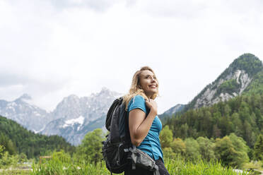 Lächelnder Rucksacktourist beim Wandern am Berg - NDEF00928