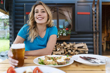 Schöne Frau genießt Bier mit Essen im Restaurant - NDEF00941
