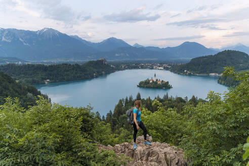 Wanderer mit Blick auf die Berge an einer Klippe stehend - NDEF00952