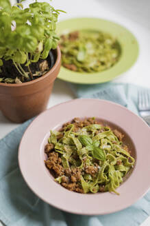 Spinach tagliatelle with bolognese sauce and basil leaves - ONAF00581