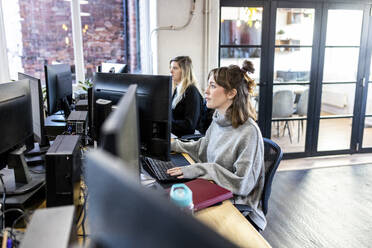 Geschäftsfrauen bei der Arbeit an einem Desktop-PC im Büro - WPEF07420