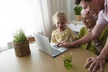 Vater unterstützt Familie bei der Nutzung des Laptops zu Hause - SVKF01510