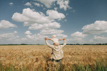 Vater trägt Sohn auf den Schultern in einem Weizenfeld - VSNF01106