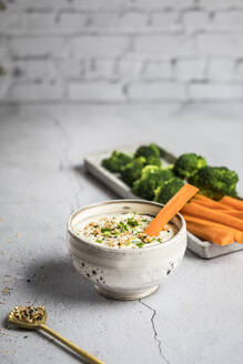 Schüssel mit Feta-Honig-Dip und rohen Möhren und Brokkoli - SBDF04639