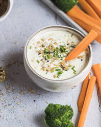 Schüssel mit Feta-Honig-Dip und rohen Möhren und Brokkoli - SBDF04641