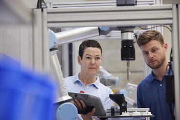 Colleagues working together in modern robotic factory - RBF09040