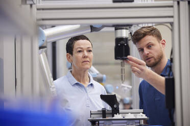 Technician explaining machine part to colleague in industry - RBF09042