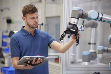 Ingenieur testet modernen Roboterarm in der Fabrik - RBF09063