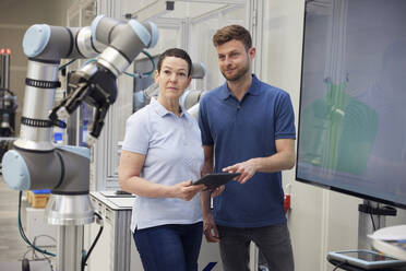 Technicians examining modern machine part standing in industry - RBF09067