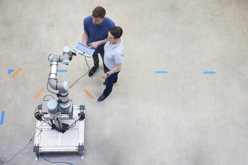 Ingenieure testen eine moderne Maschine auf dem Boden stehend in der Industrie - RBF09068