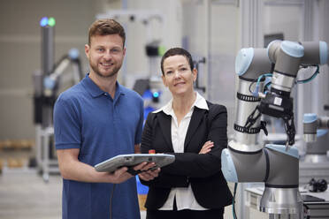 Ein selbstbewusster Manager und ein Techniker stehen neben einer Maschine in der Industrie - RBF09074