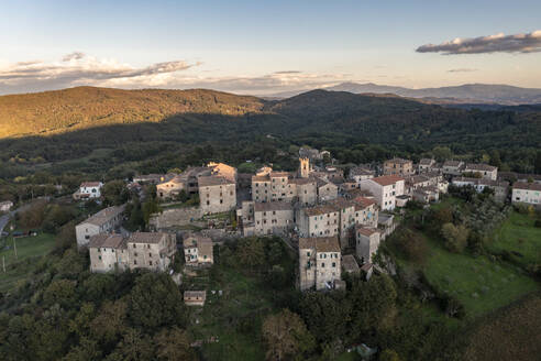 Italien, Toskana, Torniella, Luftaufnahme eines Bergdorfes in der Abenddämmerung - AMF09928