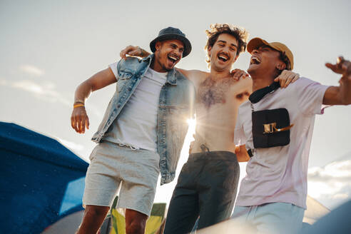 Trio of friends enjoys the happy moments of a summer festival, sharing laughter, creating memories, and celebrating the vibrant spirit of the event. This photo has intentional use of 35mm film grain. - JLPPF02180