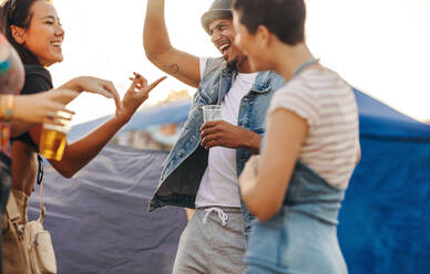 Friends embrace the festive moments at the camp, dancing, and reveling in the joyous atmosphere, creating unforgettable memories of fun and celebration. This photo has intentional use of 35mm film grain. - JLPPF02218