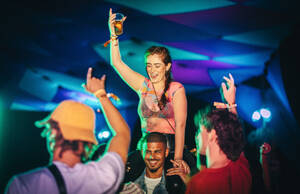 Young people come together, dancing, partying, and reveling in the captivating music at a nighttime festival, savoring the essence of summer. This photo has intentional use of 35mm film grain. - JLPPF02254