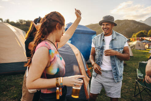 Group of friends joyfully dances and celebrates together, fully immersed in the vibrant and electrifying atmosphere of a summer music festival, creating lasting memories of shared moments of pure exhilaration. This photo has intentional use of 35mm film grain. - JLPPF02272