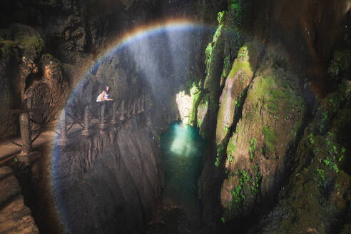 Calm female traveler standing on edge near fence and admiring picturesque scenery of river and mountains in cave during trip to Zaragoza city - ADSF44446