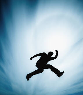 Man jumping against cloudy sky - ADSF44620