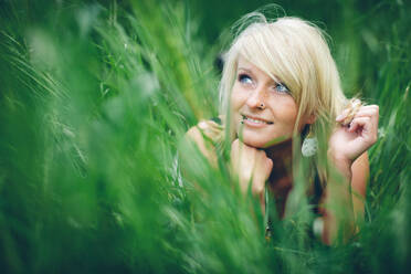 Cheerful woman lying in field - ADSF44634