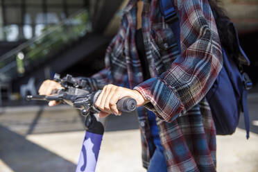 Hand eines Studenten, der in der Nähe der Universität einen Motorroller benutzt - IKF00981