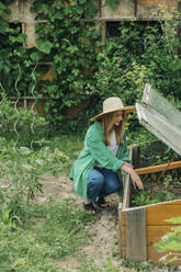 Woman planting seeds in greenhouse - VSNF01133